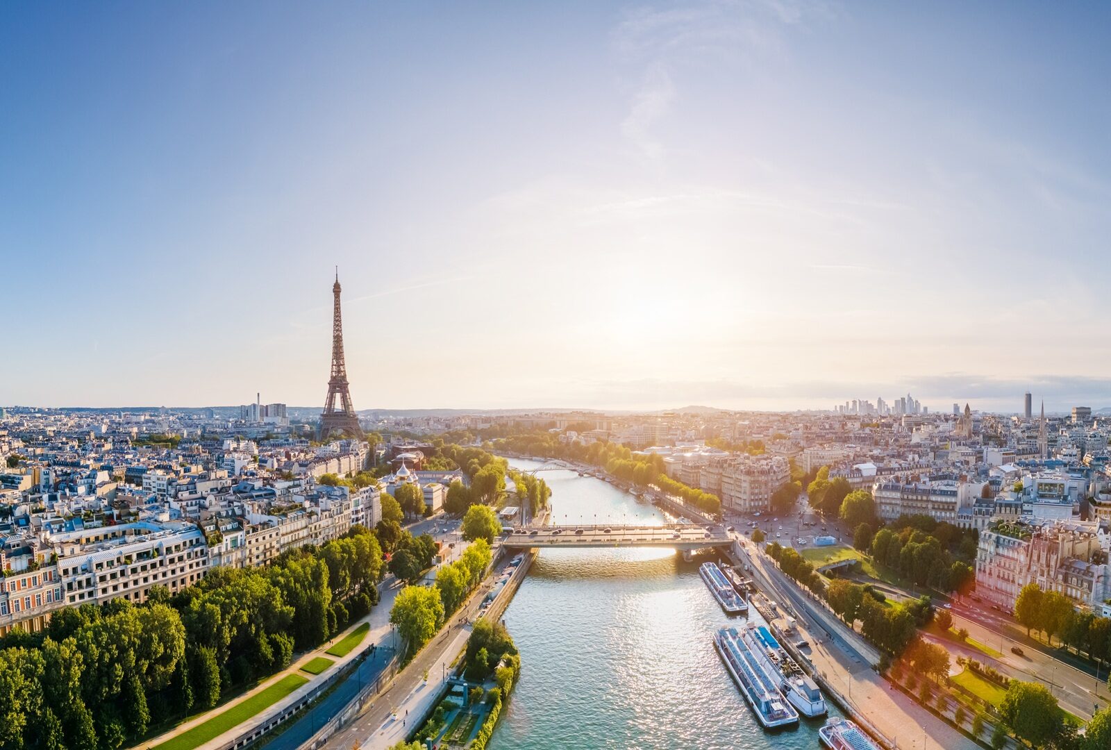 Paris aerial panorama with river Seine and Eiffel tower, France. Romantic summer holidays vacation destination. Panoramic view above historical Parisian buildings and landmarks with blue sky and sun